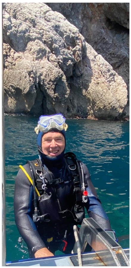 Plongeur dans l'eau turquoise au pied d'une falaise
