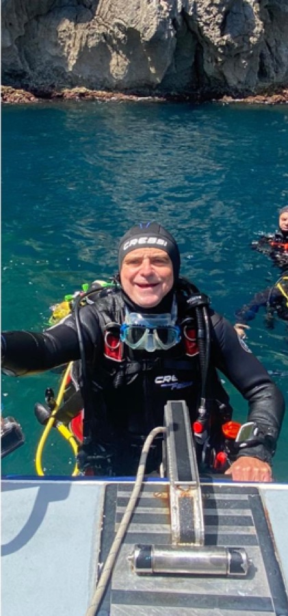 Plongeur souriant à la surface près de l'échelle du bateau